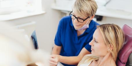 ZFA zeigt Patientin Röntgenaufnahmen